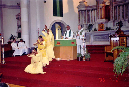 A group of girls perform a Hindu dance at the altar during mass